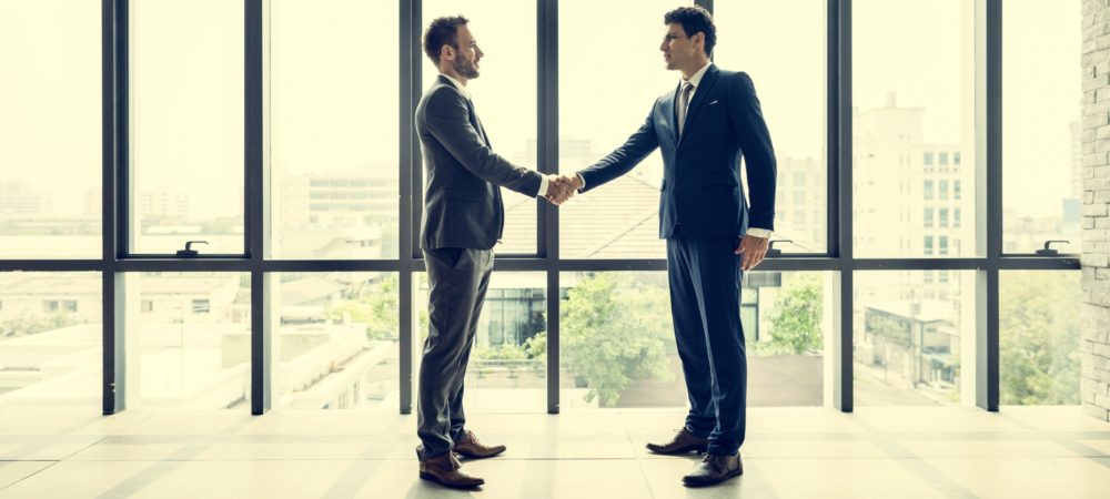 businessman-handshake-corporate-colleagues-PJYGZ45-scaled